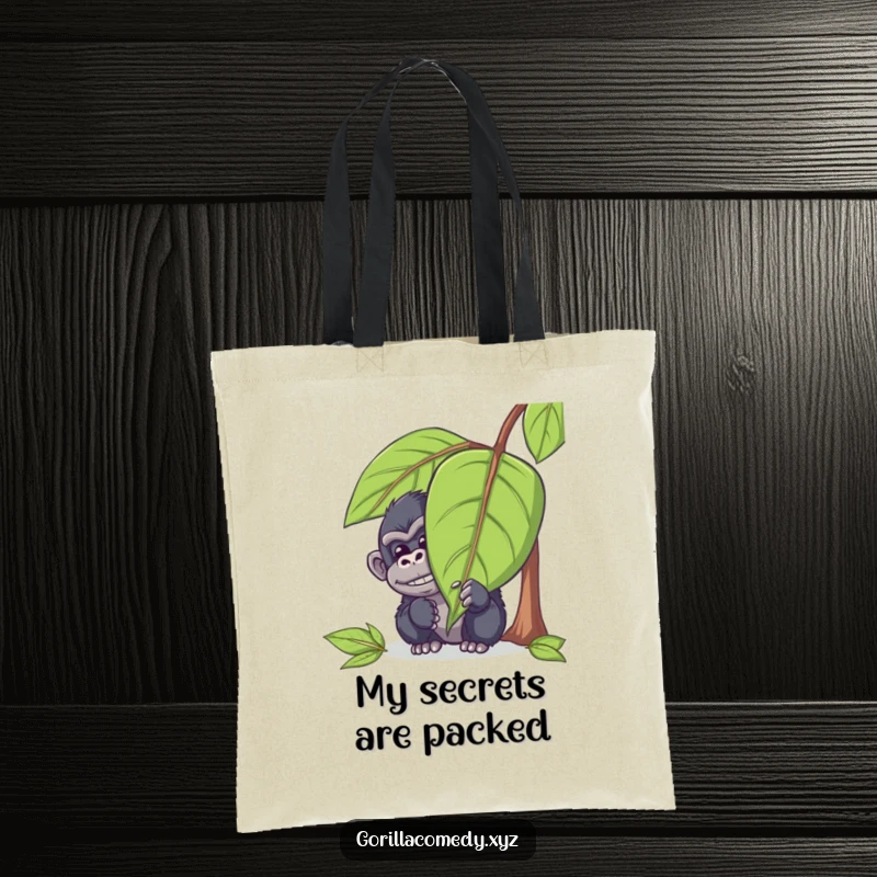 Funny gorilla tote bag with a mischievous ape character peeking out from behind a large leaf with a chuckle, great for carrying items with amusement.